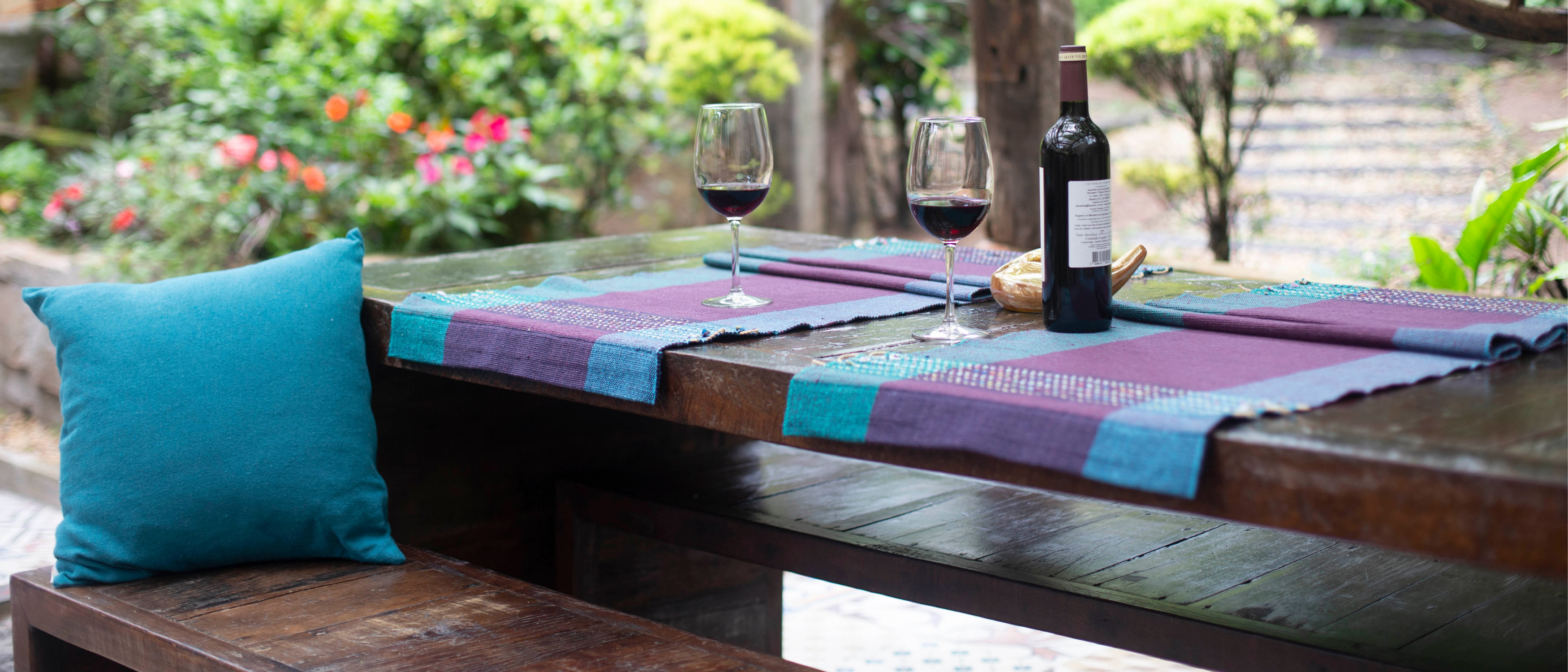 Blue cushion on bench seat with blue and pruple table cloth